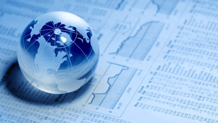 Glass globe sitting on top of financial readouts