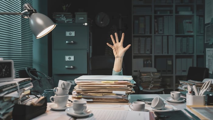 Desperate office worker overwhelmed with paperwork, she is asking help with her hand