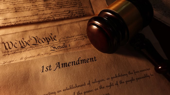 picture of the US constitution focused on the 1st Amendment with a judge's gavel.