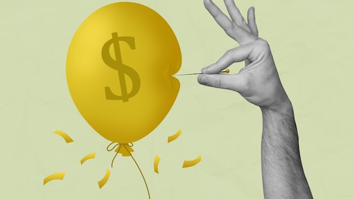 A needle bursting balloon with a dollar sign