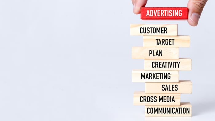 Businessman Building ADVERTISING Concept with Wooden Blocks - Image